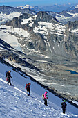 Several persons descending on glacier from Gran Paradiso, Gran Paradiso, Gran Paradiso Nationalpark, Graian Alps range, valley of Aosta, Aosta, Italy