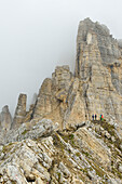 Personen gehen über Felsgrat zum Torre di Pisa, Latemar, Dolomiten, UNESCO Welterbe Dolomiten, Trentino, Italien