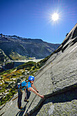 Woman climbing on granite slab, Azalee Beach, Grimsel pass, Bernese Oberland, Switzerland