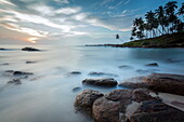 Sunrise at a secluded lagoon with rocks and palm trees framing the view, Tangalle, Sri Lanka, Indian Ocean, Asia