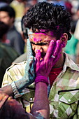 Two men exchange coloured powder during Holi festival celebrations, Basantapur Durbar Square, Kathmandu, Nepal, Asia