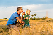 Vater und Sohn (4 Jahre) auf einer Wiese, Marielyst, Falster, Dänemark