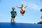 Vater und Sohn (4 Jahre) springen auf einem Trampolin, Marielyst, Falster, Dänemark