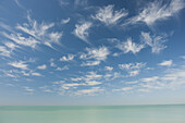 Wispy clouds over tranquil sea
