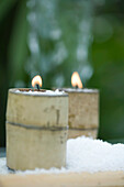 Candles in bamboo holders surrounded by snow