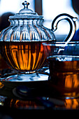 Glass teapot and tea in glass tea cup, backlit