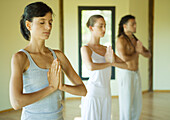 Yoga class standing in prayer position