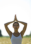 Frau in Yogastellung auf einem Feld
