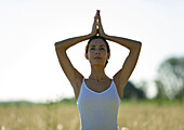 Frau in Yogastellung auf einem Feld