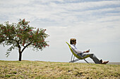 Man relaxing outdoors looking at cell phone