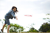 Woman throwing flying disc at park
