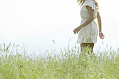 Young woman walking in meadow, cropped