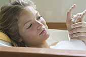 Young woman relaxing in bubble bath