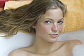 Young woman relaxing in bubble bath, portrait