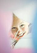 Girl looking through bunch of balloons