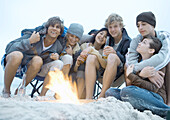 Group of friends sitting around campfire