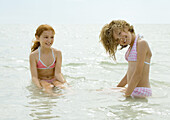 Girls sitting in shallow water