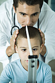 Doctor measuring boy during check-up