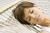 Woman relaxing on hammock, close-up