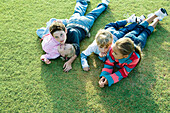 Children lying on grass together