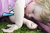 Toddler girl taking a nap outdoors