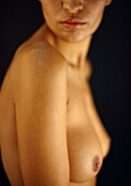 Nude woman's chest and lower face, side view