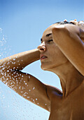 Woman taking shower, close-up