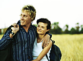 Man with arm around woman, smiling