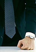Businessman pressing fist against table, close-up