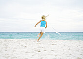 Girl running after seagull on beach