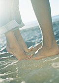 Teenage couple, girl standing on tiptoes, close-up of lower legs and feet