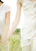 Two young women outdoors, holding hands