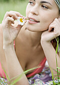 Young woman with flower stem in mouth