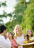 Family sitting at table outside