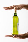 Hands holding bottle of white wine