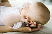 Infant lying on mother's hands, cropped
