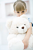 Little girl holding large teddy bear, portrait
