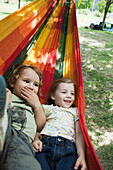 Young brother and sister lying in hammock together