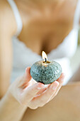 Woman holding up candle, cropped