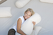 Young woman hugging pillow on bed