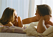 Couple lying in bed talking