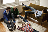 Four teenage friends hanging out in a living room