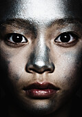 Portrait of a teenage girl with silver paint on her face