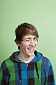 A teenage boy winking playfully, portrait, studio shot