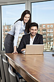 A businessman and businesswoman having a meeting in a board room