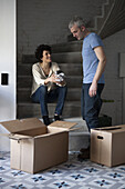 A mixed age couple packing moving boxes
