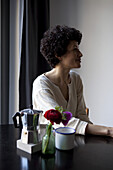 A smiling woman looking away while sitting at a table