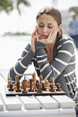 Girl plays chess outside