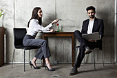 Ein Geschäftsmann und eine Geschäftsfrau bei einer Besprechung in einem modernen Büro