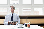 A businessman using a digital tablet on his lunch break